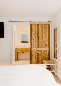 a sliding barn door in a bedroom with a desk at Hotel Henry Cafe and Bar in Blanco