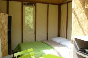 a bedroom with a bed in a room with a window at ZEcamping 3 chiens acceptés hammam piscine chauffée in Louvie-Juzon