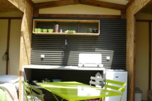 a kitchen with a green table and a refrigerator at ZEcamping 3 chiens acceptés hammam piscine chauffée in Louvie-Juzon