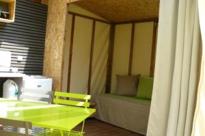 a room with a green table and a couch at ZEcamping 3 chiens acceptés hammam piscine chauffée in Louvie-Juzon