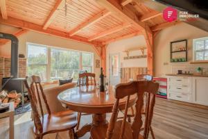 a kitchen and dining room with a table and chairs at Le Pèlerin - Chalet rustique Écoresponsable en nature - Estrie in Notre-Dame-Des-Bois +41 photos