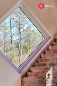 a window in a stairwell with a view of trees at Le Pèlerin - Chalet rustique Écoresponsable en nature - Estrie in Notre-Dame-Des-Bois