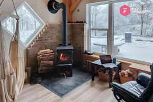 a living room with a fireplace and a stove at Le Pèlerin - Chalet rustique Écoresponsable en nature - Estrie in Notre-Dame-Des-Bois