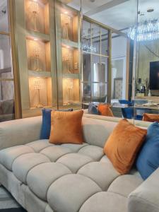 a living room with a couch with pillows on it at Deluxe Suites Razelles 2 at Shore 2 Residences Tower 1 in Manila