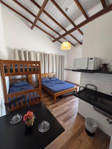 a living room with two beds and a table at Pousada da Árvore in Boicucanga +64 photos