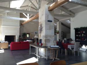 a large room with a fireplace and tables and chairs at La Grange d'Aunis in Aigrefeuille-dʼAunis