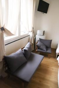 a living room with a couch and a window at Hôtel & Restaurant ISVARA in Breteuil