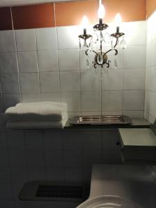 a bathroom with a chandelier on a tiled wall at Corte di Maggio B&B in Imola +43 photos