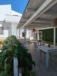 a patio with tables and chairs and a wooden deck at Sottovento Marzamemi Rooms&Relax in Marzamemi