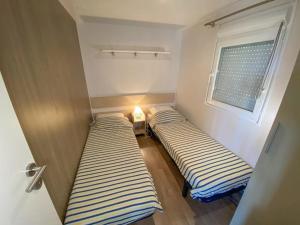 two beds in a small room with a window at Camping 3 étoiles - ccaidff in Beaulieu +63 photos