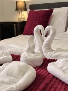 two swans shaped like hearts sitting on a bed at Ocean View Guest House in São Vicente