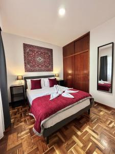 a bedroom with a large bed with a red blanket at Ocean View Guest House in São Vicente