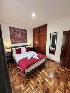 a bedroom with a large bed with red pillows on it at Ocean View Guest House in São Vicente