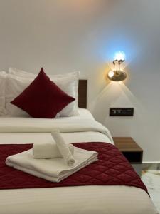 a hotel room with two white towels on a bed at Hotel Materhorn in Kovalam