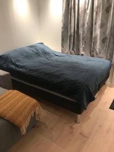 a bed with a blue comforter in a bedroom at Koselig og praktisk studioleilighet in Svolvær +6 photos