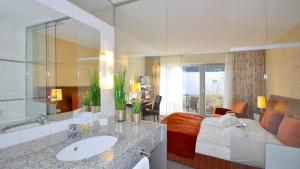a bathroom with a sink and a large mirror at Wellings Romantik Hotel zur Linde in Moers