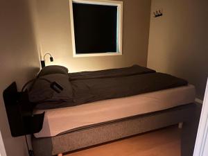 a bed in a small room with a window at Sentral toppleilighet 3.etg 4 pers in Svolvær