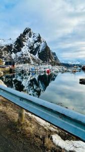 a reflection of a mountain in a body of water at Sentral toppleilighet 3.etg 4 pers in Svolvær