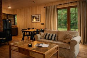 a living room with a couch and a table at Leśna Przystań apartamenty dwupoziomowe nad jeziorem in Węgorzewo