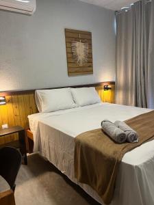 a bedroom with a large bed with towels on it at Bangalôs Riviera do Patacho in Pôrto de Pedras +37 photos