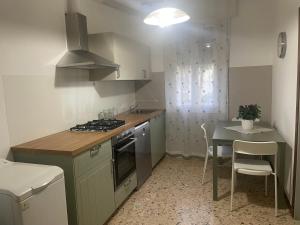 a kitchen with a stove and a table with chairs at B&B Il Maggiociondolo in Fontaniva