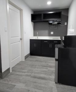 a kitchen with black cabinets and a white door at Rodeway Inn in Livingston
