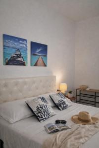a bedroom with a bed with a hat and sunglasses on it at La riva in Noto Marina +67 photos