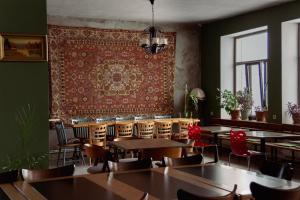 a restaurant with tables and chairs and a rug on the wall at Black Castle Red Valley in Sevaberd