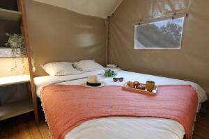 a bedroom with a bed with a hat and a tray of food at ZEcamping 3 dog friendly salle fitness piscine in Vensac