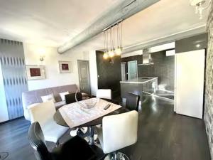 a dining room and living room with a table and chairs at Le VILLAJOUN in Saintes-Maries-de-la-Mer