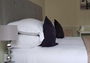 ein Bett mit weißen und schwarzen Kissen in der Unterkunft Fernhill Hotel in Lyme Regis
