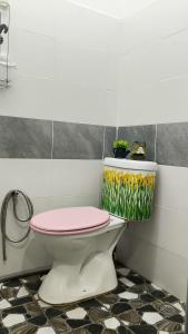 a bathroom with a toilet with a pink lid at KAMI roomstay 2 in Kampong Banggol Lalang