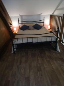 a bedroom with a bed with two lamps on the floor at Maisonnette La Bienvenue in Trainel