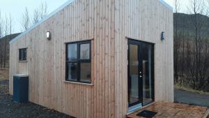 a wooden house with two windows on the side of it at Skard Cottages in Fludir