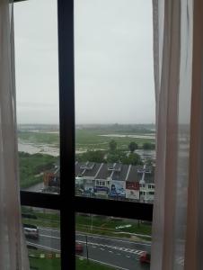 a window with a view of a road and buildings at Wafiq Studio in Kota Bharu
