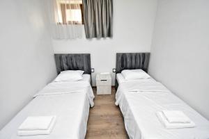 a row of three beds in a room at Riposo Hotel Armenia in Pʼarakʼar