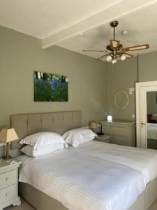 ein Schlafzimmer mit einem weißen Bett und einem Deckenventilator in der Unterkunft Fernhill Hotel in Lyme Regis