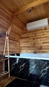 a room with wooden walls and a ceiling with a heater at Akorya bungalov in Ardeşen