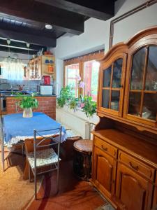 a kitchen with a table and a wooden cabinet at Villa Vadása Vendégház in Hegyhátszentjakab
