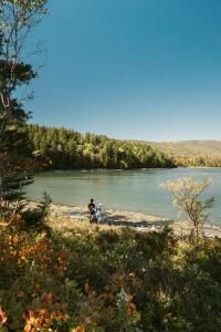 zwei Menschen stehen am Ufer eines Sees in der Unterkunft Ferncrest Acadia in Sargentville