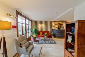 a living room with two chairs and a couch at Best Western Le Pont d'Or in Figeac
