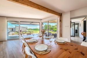 a dining room with a wooden table and chairs and a large window at Weekend dans la villa Léonie in Kerlouan