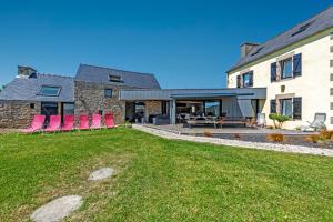 an exterior view of a house with pink chairs at Weekend dans la villa Léonie in Kerlouan