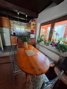 a kitchen with a wooden table and some plants at Villa Vadása Vendégház in Hegyhátszentjakab