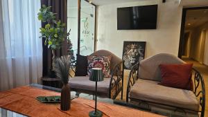 ein Wohnzimmer mit zwei Stühlen und einem Tisch in der Unterkunft Hotel NIRÁ in Sofia