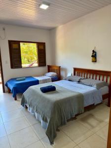 a bedroom with two beds and a window at Flats Coco Coral in Barra Grande