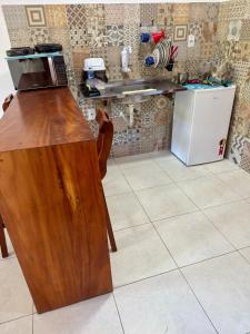 a kitchen with a counter with a microwave and a refrigerator at Flats Coco Coral in Barra Grande +4 photos
