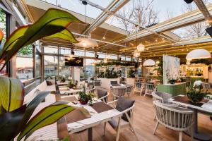 a restaurant with tables and chairs and windows at Hotel Saftica in Săftica