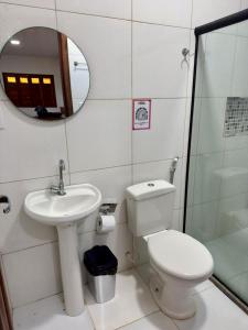a bathroom with a toilet and a sink and a mirror at Flats Coco Coral in Barra Grande