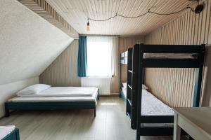 a bedroom with two bunk beds and a window at Cabana Vitus Panzió in Harghita-Băi